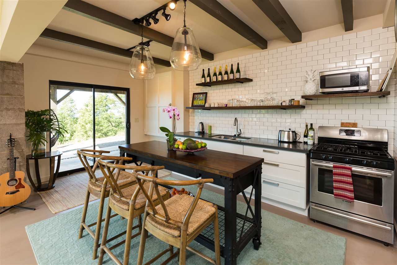 320 Lower Kimo Drive Kula, HI 96790 - Photo 21 of 27 a kitchen with stainless steel appliances granite countertop a stove a sink dishwasher a dining table and chairs with wooden floor