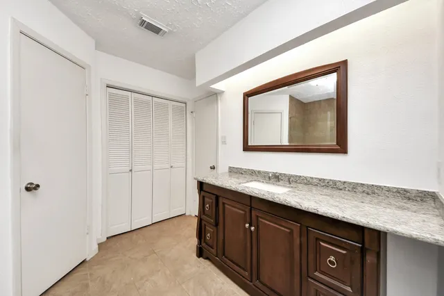 a bathroom with a granite countertop sink vanity and mirror