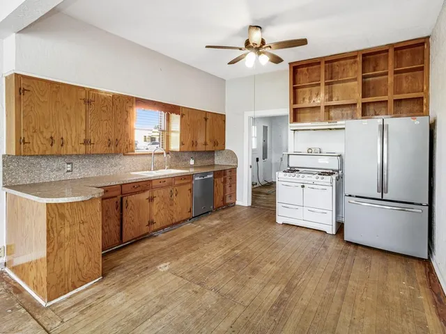 a kitchen with stainless steel appliances granite countertop a stove a sink and a refrigerator
