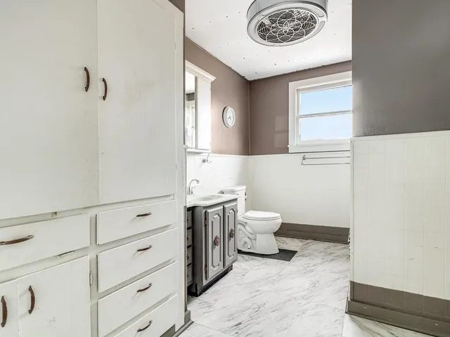 a bathroom with a sink a toilet and a window