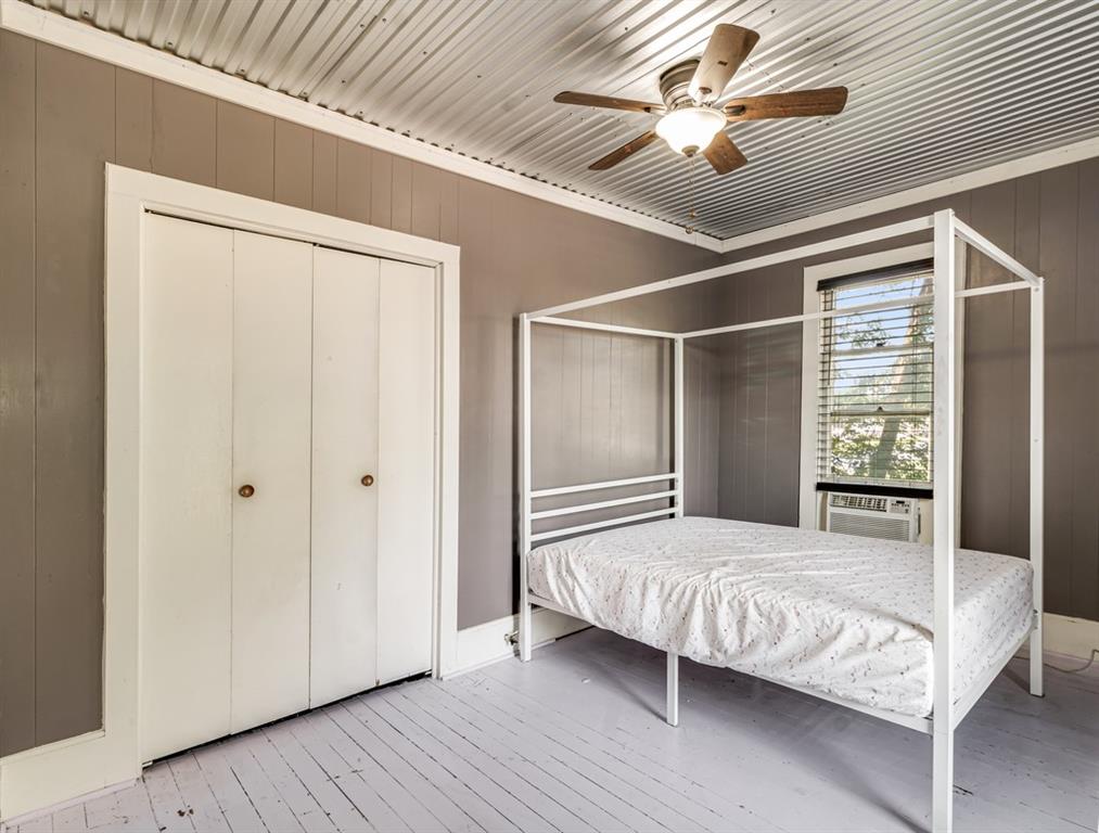 112 West Hackberry Street Malone, TX 76660 - Photo 22 of 38 a bedroom with a bed and a chandelier