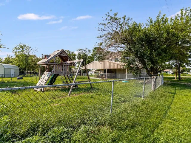 a view of a house with a backyard and a tree