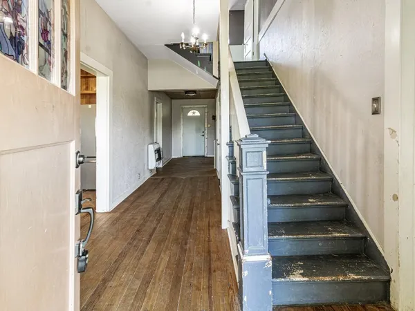 a view of a hallway with wooden floor and staircase
