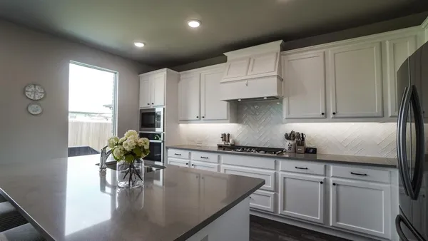 a kitchen with a refrigerator stove and white cabinets
