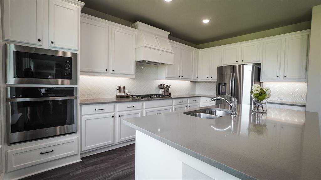 1836 Big Spring Drive Forney, TX 75126 - Photo 13 of 40 a kitchen with a refrigerator stove and white cabinets