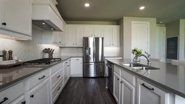 a kitchen with granite countertop a sink stove and refrigerator