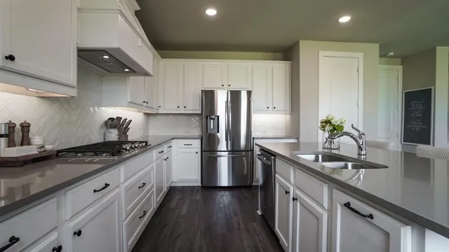 a kitchen with granite countertop a sink stove and refrigerator