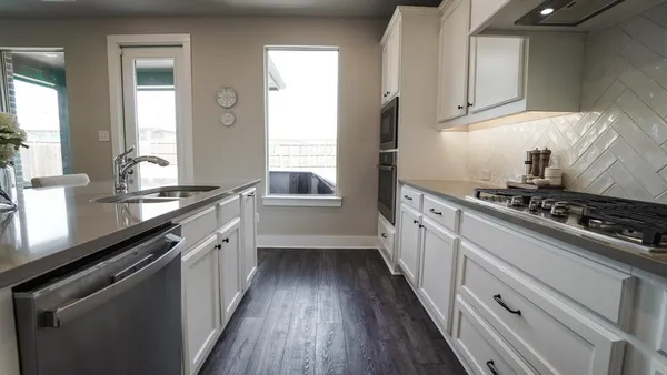 a bedroom with a large bed chandelier and a window