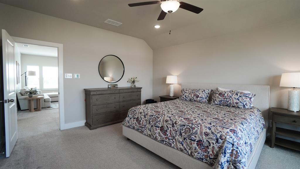 1836 Big Spring Drive Forney, TX 75126 - Photo 17 of 40 a bedroom with a bed and a chandelier