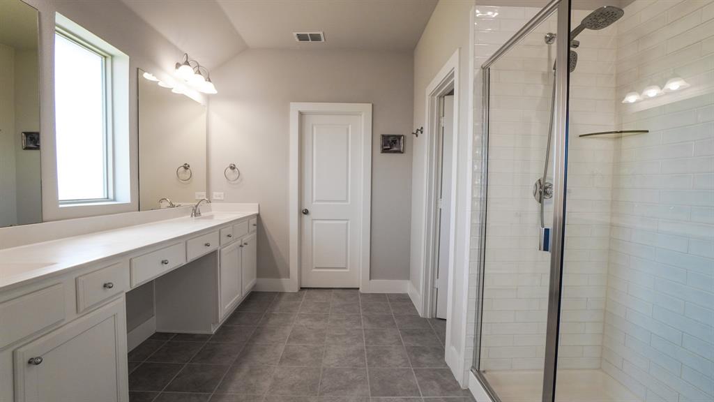 1836 Big Spring Drive Forney, TX 75126 - Photo 18 of 40 a bathroom with a double vanity sink a mirror and a shower
