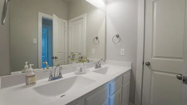 a bathroom with a double vanity sink mirror and next to a window