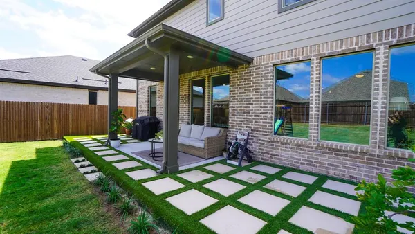 a view of a swimming pool with a patio and a yard