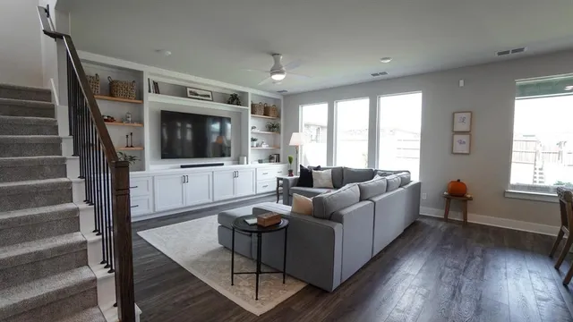 a living room with furniture a flat screen tv and a window