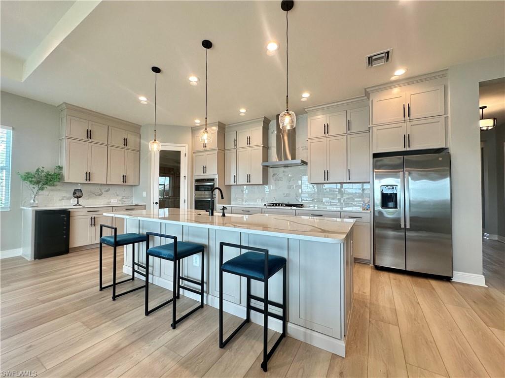 3998 Perseus Street Naples, FL 34120 - Photo 4 of 26 Kitchen featuring stainless steel appliances, decorative backsplash, light stone countertops, and recessed lighting