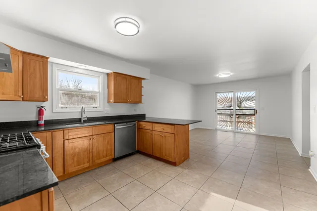 a kitchen with granite countertop a stove a sink and a cabinets
