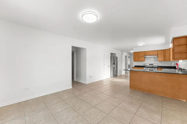 a view of an empty room with kitchen