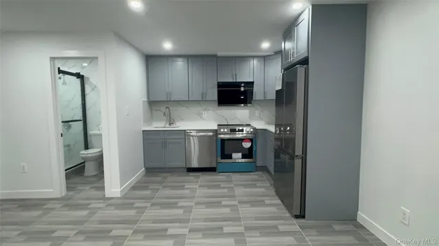 a kitchen with stainless steel appliances granite countertop a refrigerator a sink and a stove