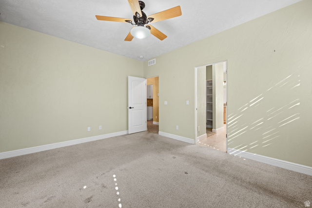 20 Valley Road Leeds, UT 84746 - Photo 20 of 57 Spacious room with light-colored walls, carpeted flooring, and a ceiling fan with light fixture