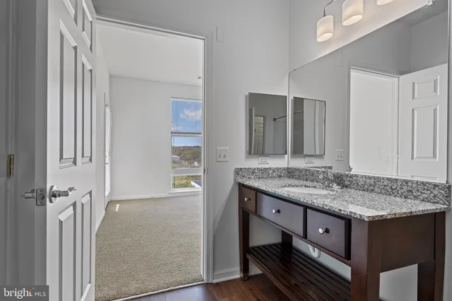 a bathroom with a granite countertop sink and a mirror