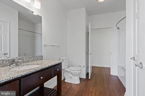 a bathroom with a granite countertop sink toilet and shower