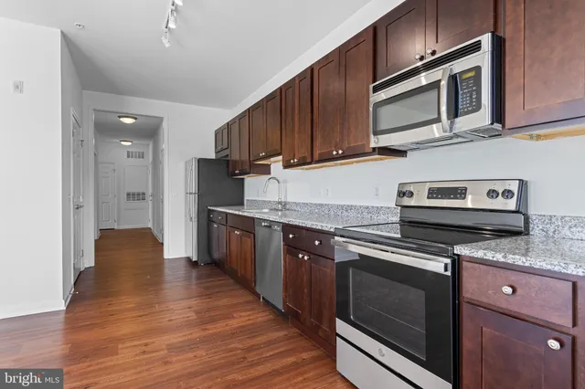 a kitchen with stainless steel appliances granite countertop wooden cabinets granite counter tops and a stove