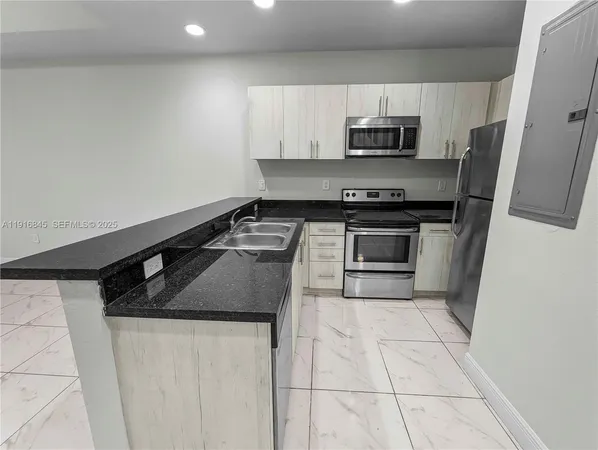 a kitchen with stainless steel appliances granite countertop a refrigerator and a sink
