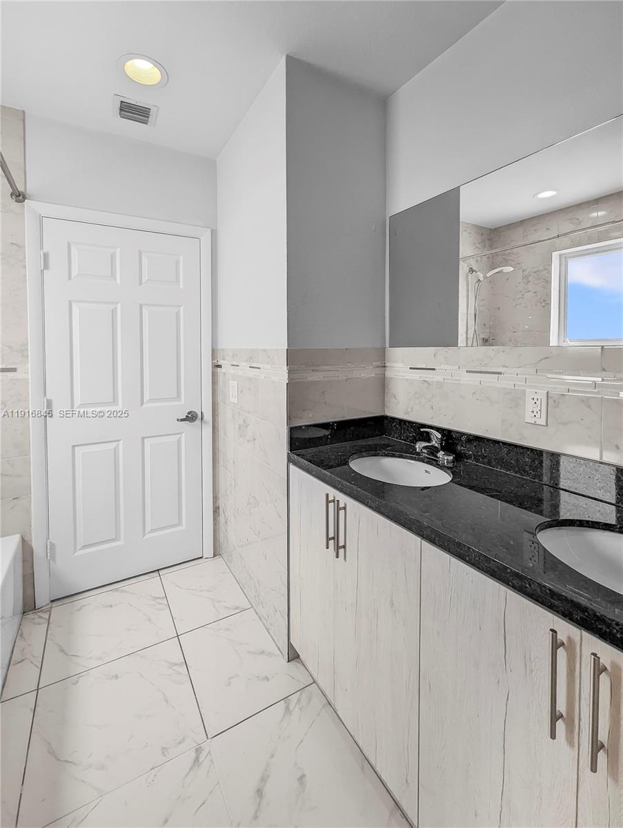 850 Southwest 14th Avenue, Unit 4 Miami, FL 33135 - Photo 15 of 30 a bathroom with a granite countertop sink and a mirror