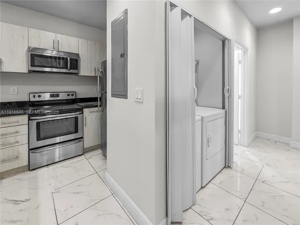 a kitchen with stainless steel appliances a stove a microwave and a sink