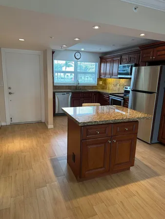 a kitchen with stainless steel appliances granite countertop a sink and a stove