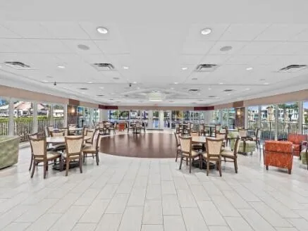 a dining room with lots of tables a large window and chairs