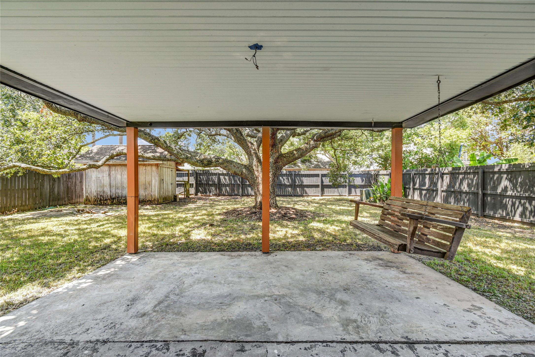 16 Ranch House Loop Angleton, TX 77515 - Photo 32 of 34 covered patio with large tree in the back and shed, fully fenced backyard