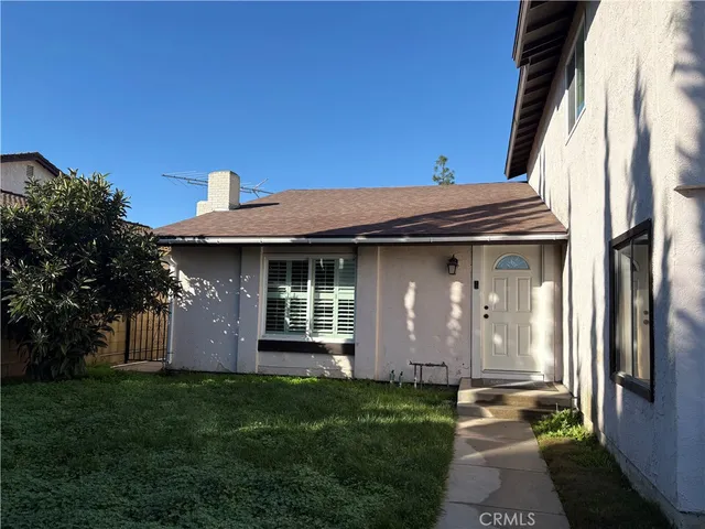 a view of a house with brick walls and a yard with plants