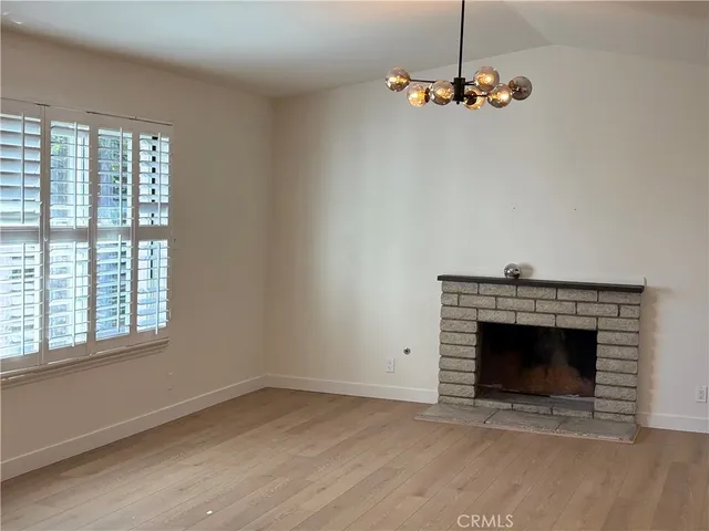 an empty room with a fireplace and windows
