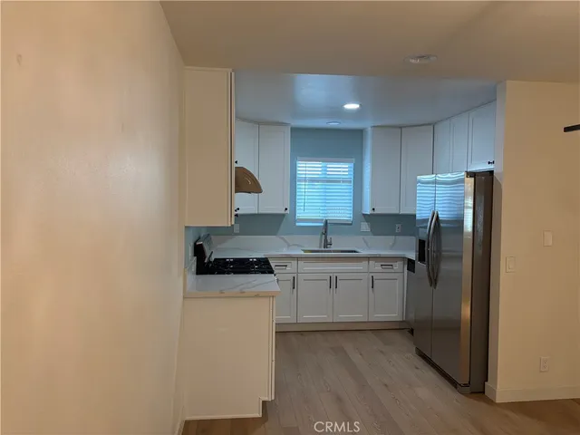 a kitchen with a sink a refrigerator a stove and white cabinets