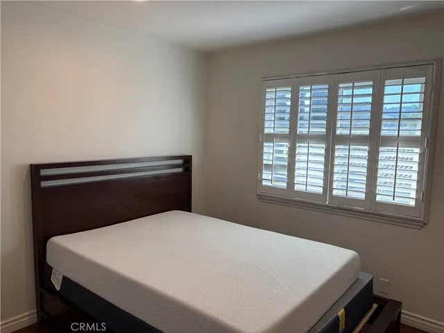 a bed sitting in a bedroom next to a window