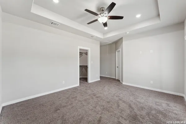 an empty room with ceiling fan and window