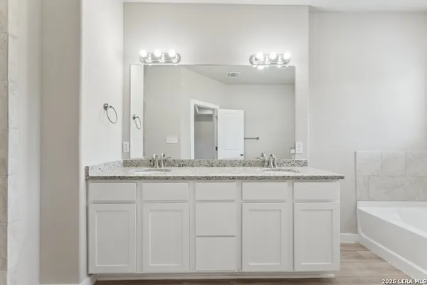 a bathroom with a granite countertop sink and a mirror