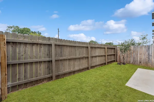 a view of a backyard with wooden fence
