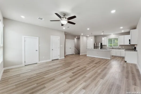 a view of an empty room and kitchen view