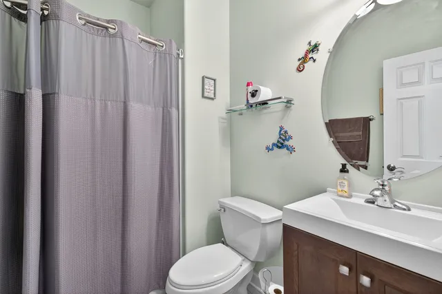 a bathroom with a sink a toilet and shower curtain