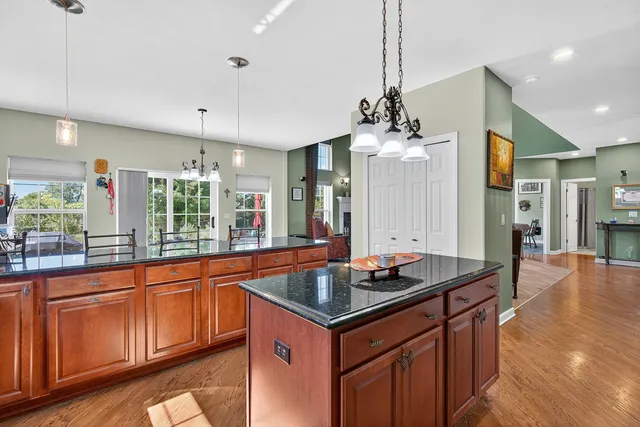 a kitchen with granite countertop a sink cabinets and wooden floor