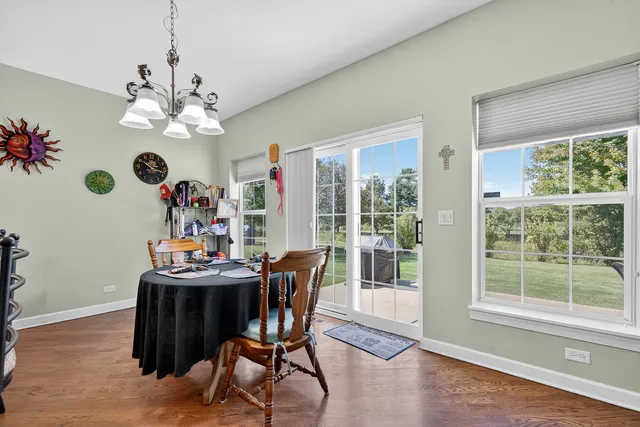 a view of a dining room with furniture a chandelier and wooden floor