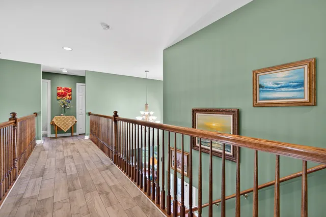 a view of a hallway with wooden floor and stairs