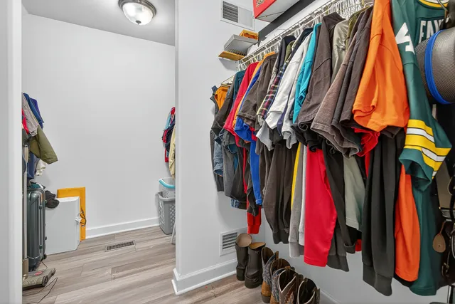 a view of walk in closet with clothes and shoes