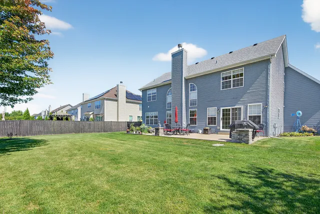 a view of a house with a yard and sitting area