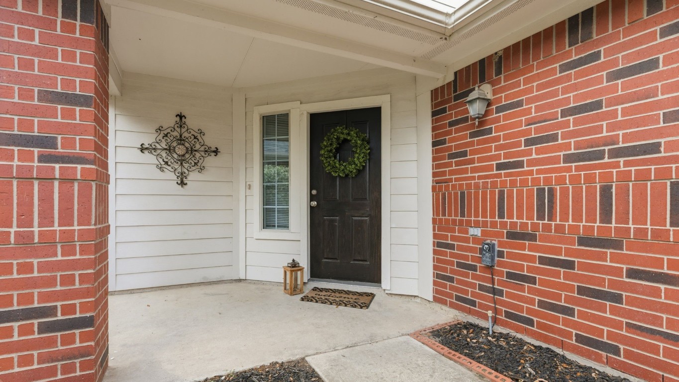 1427 Hade Falls Lane Houston, TX 77073 - Photo 3 of 31 This welcoming entryway features a brick exterior with white siding accents, a black front door and a covered porch area.
