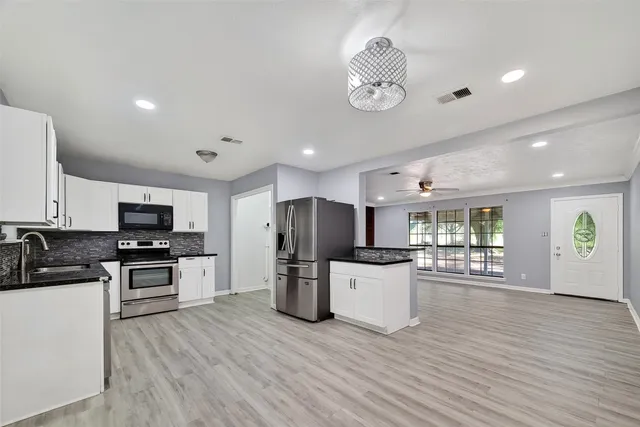 a kitchen with stainless steel appliances wooden floor and refrigerator