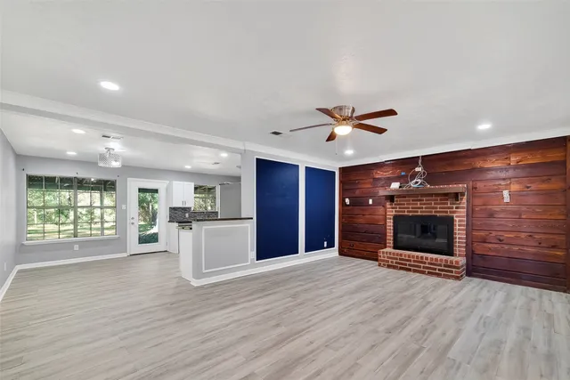a view of a livingroom with a fireplace wooden floor and window