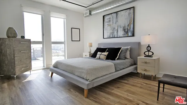 a bedroom with a bed and wooden floor