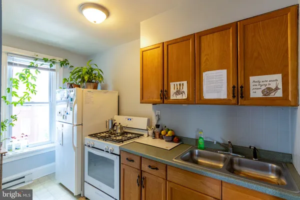 a kitchen with stainless steel appliances a sink a refrigerator and a window